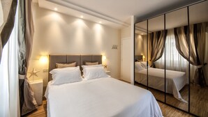 Habitación de hotel con una cama grande, lámparas de noche, una decoración con forma de estrella de mar y un espejo con cortinas.