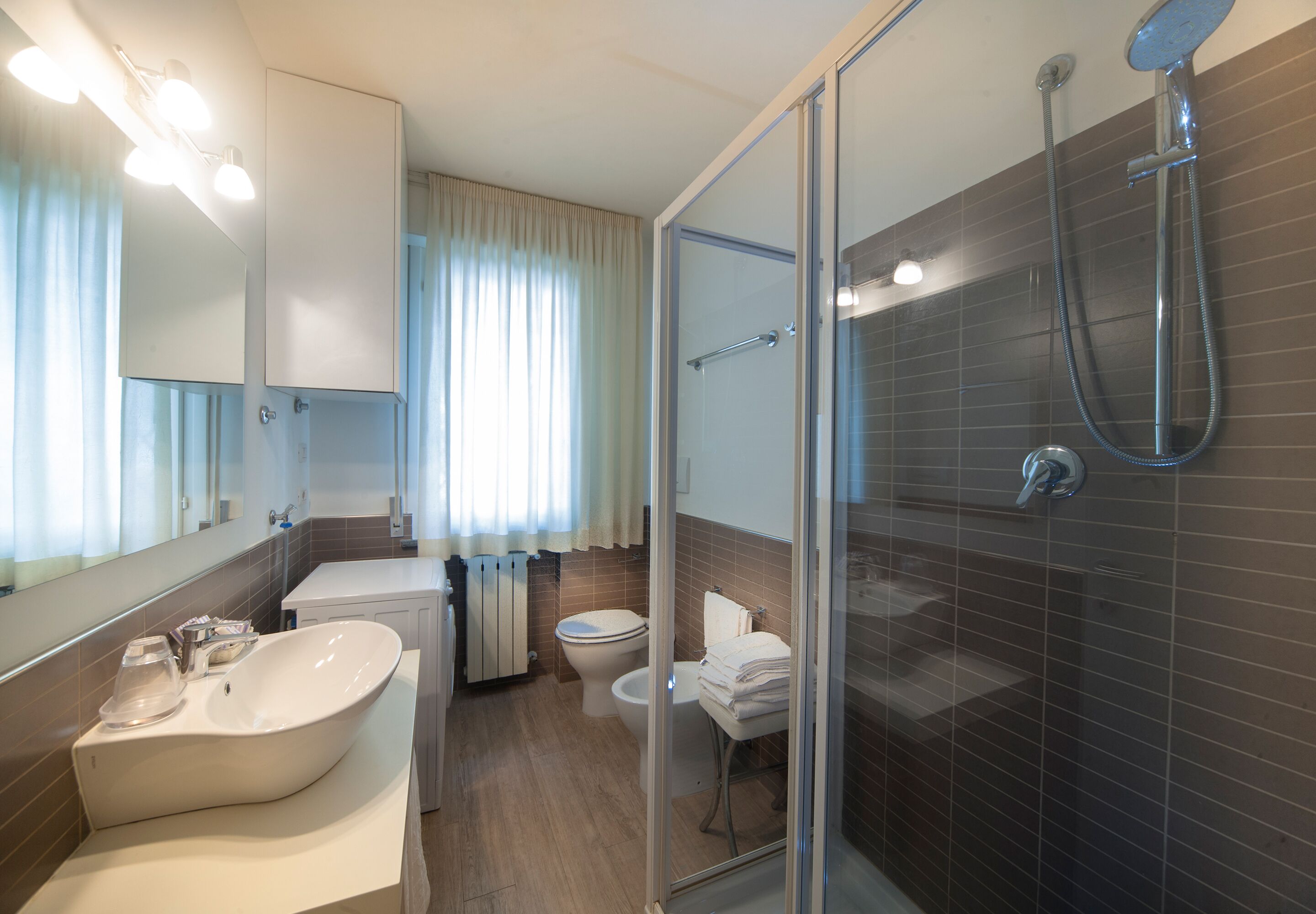 A modern bathroom with a freestanding bathtub, a glass-enclosed shower, and a toilet.