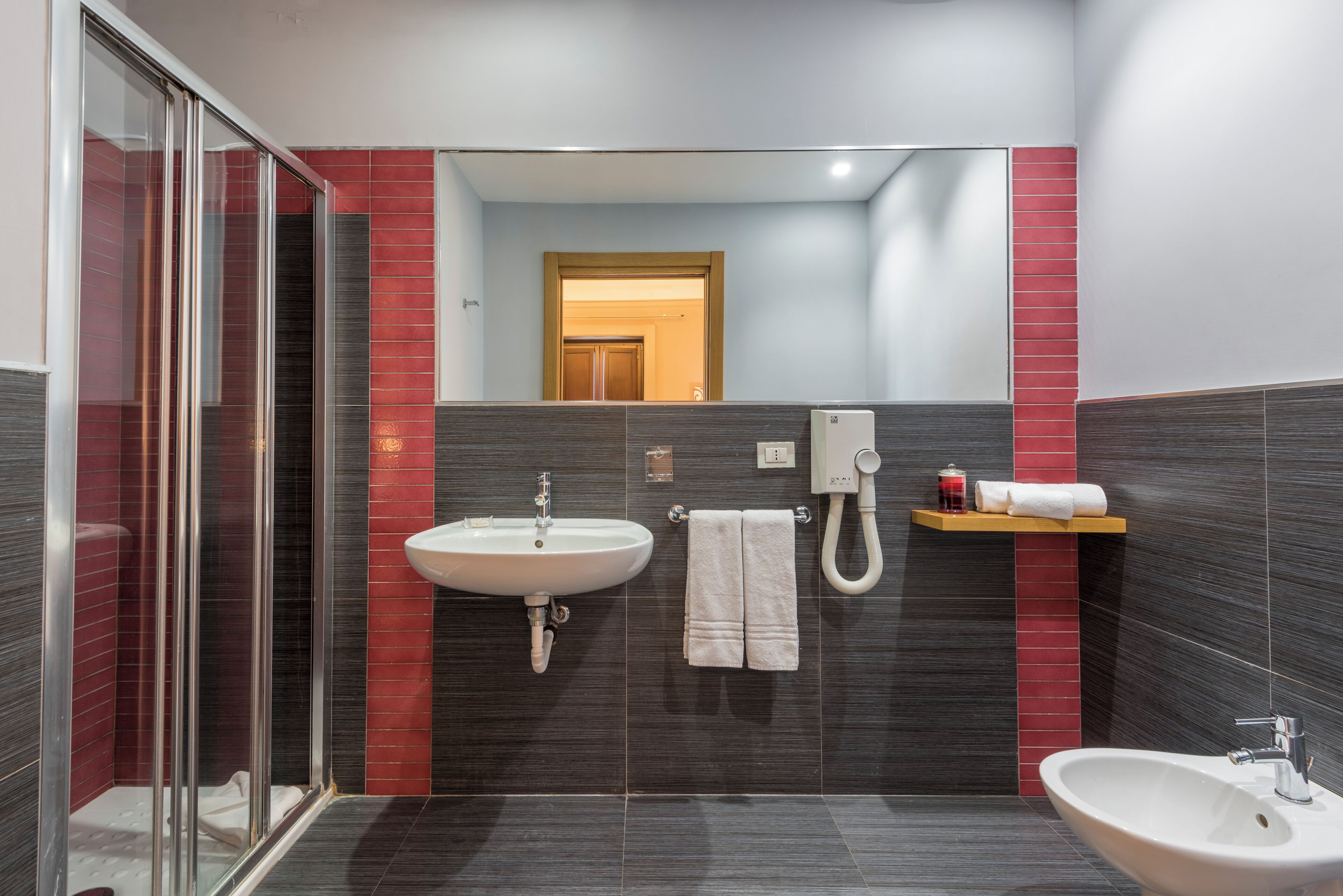 Une salle de bain moderne avec une douche à parois de verre, un lavabo et un bidet.