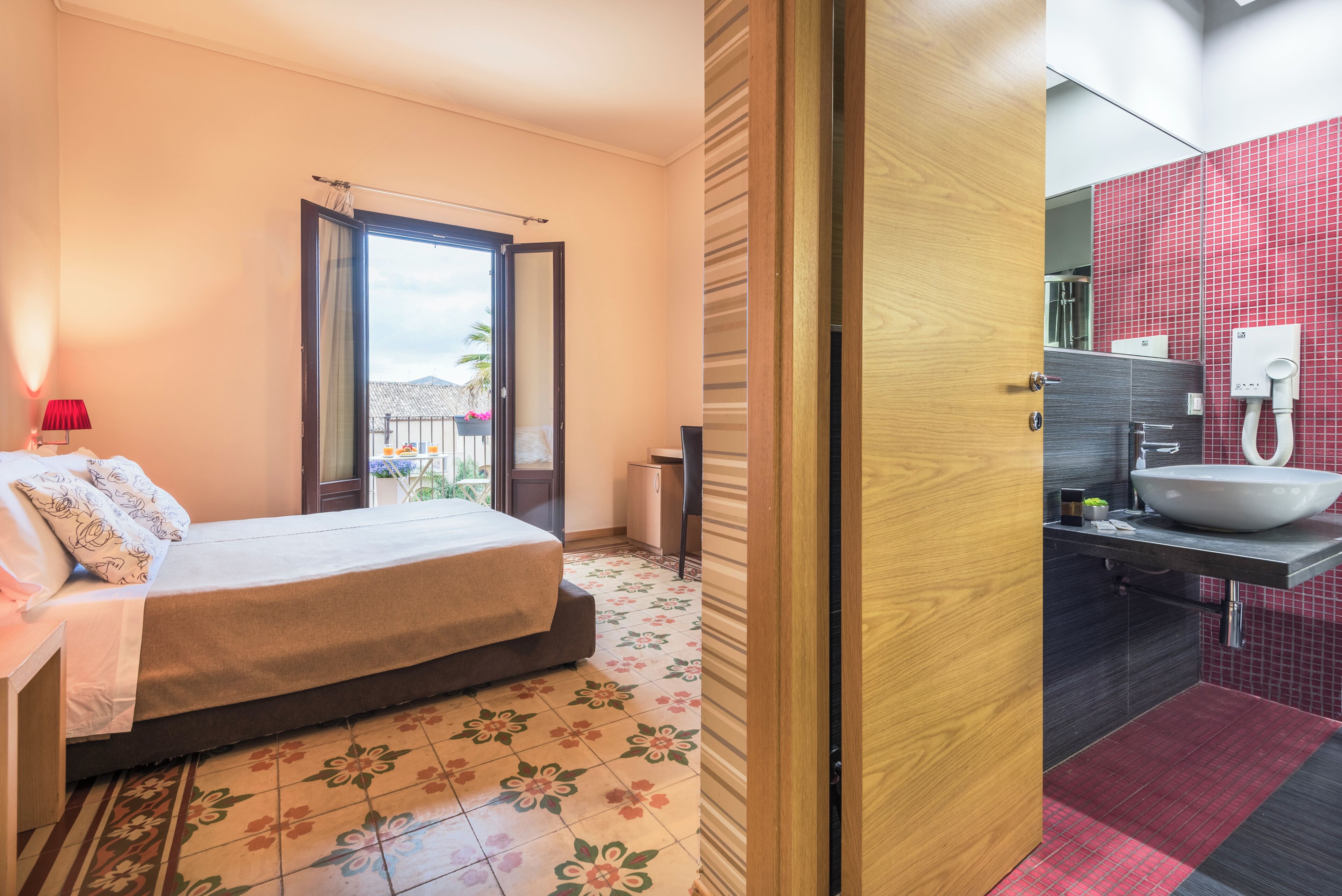 Un dormitorio con cama, ventana con cortinas y vista al exterior.