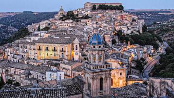 A densely packed historic town with a prominent church featuring a blue dome and a bell tower.