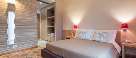 Un dormitorio con cama, mesitas de noche, armario y lámpara de pared.