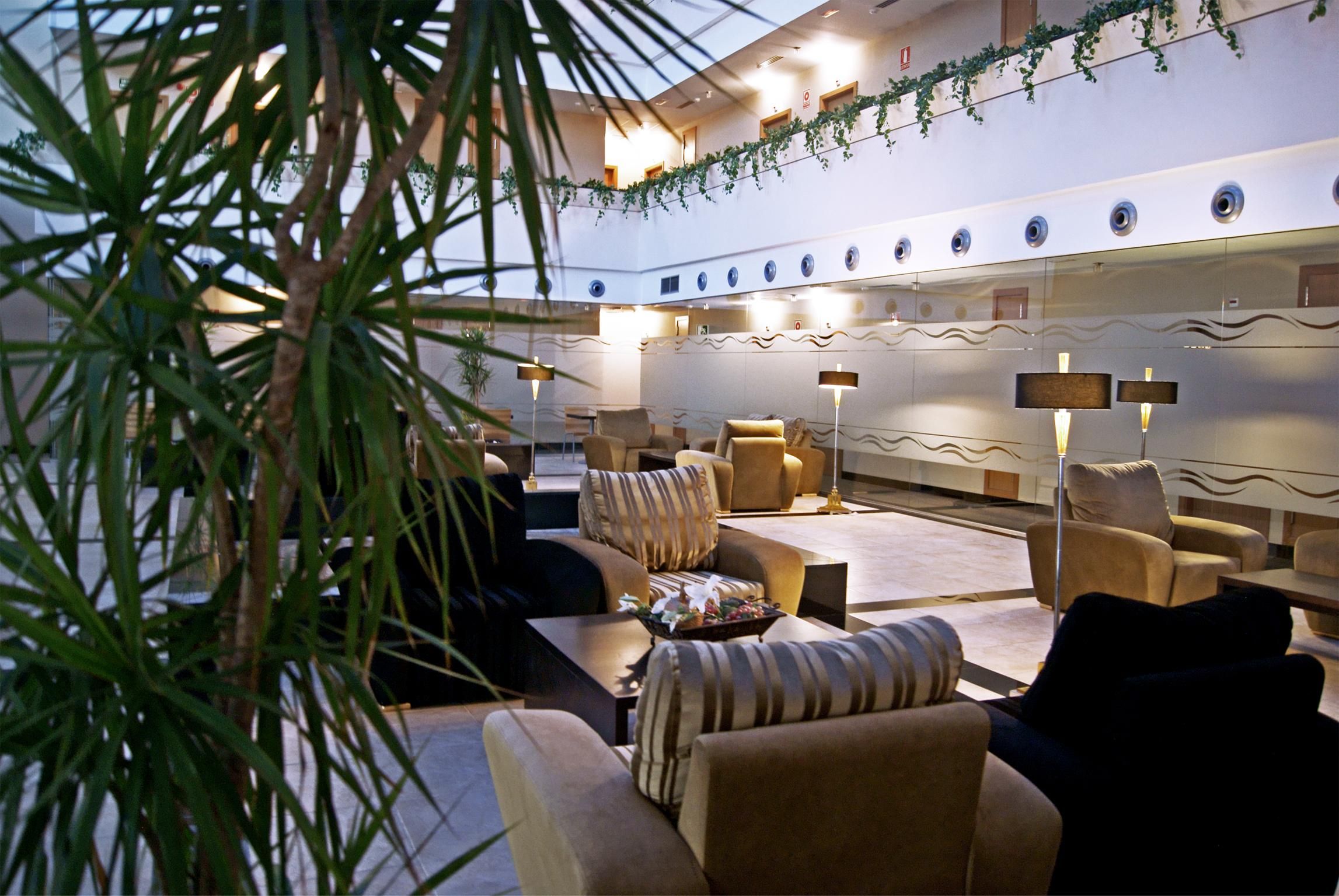 A hotel lobby with sofas, armchairs, and a coffee table.