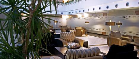 A hotel lobby with sofas, armchairs, and a coffee table.