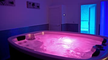 Relax in a spacious bathroom with a large hot tub and a separate door leading to another room.