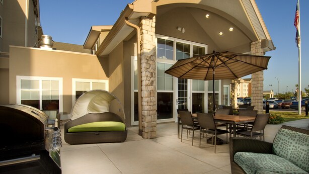 An outdoor patio area with a dining table, chairs, a grill, and a cushioned seating area. - Residence Inn by Marriott San Antonio SeaWorld/Lackland (San Antonio)