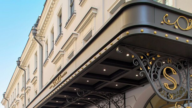 A hotel facade with a classic architectural style, featuring a curved entrance canopy with ornate metalwork and a prominent 'S' logo. - Hotel Saski Krakow, Curio Collection by Hilton (Kraków)