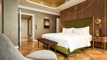 Una habitación de hotel moderna con una cama grande, un banco y una pequeña mesa con un florero.