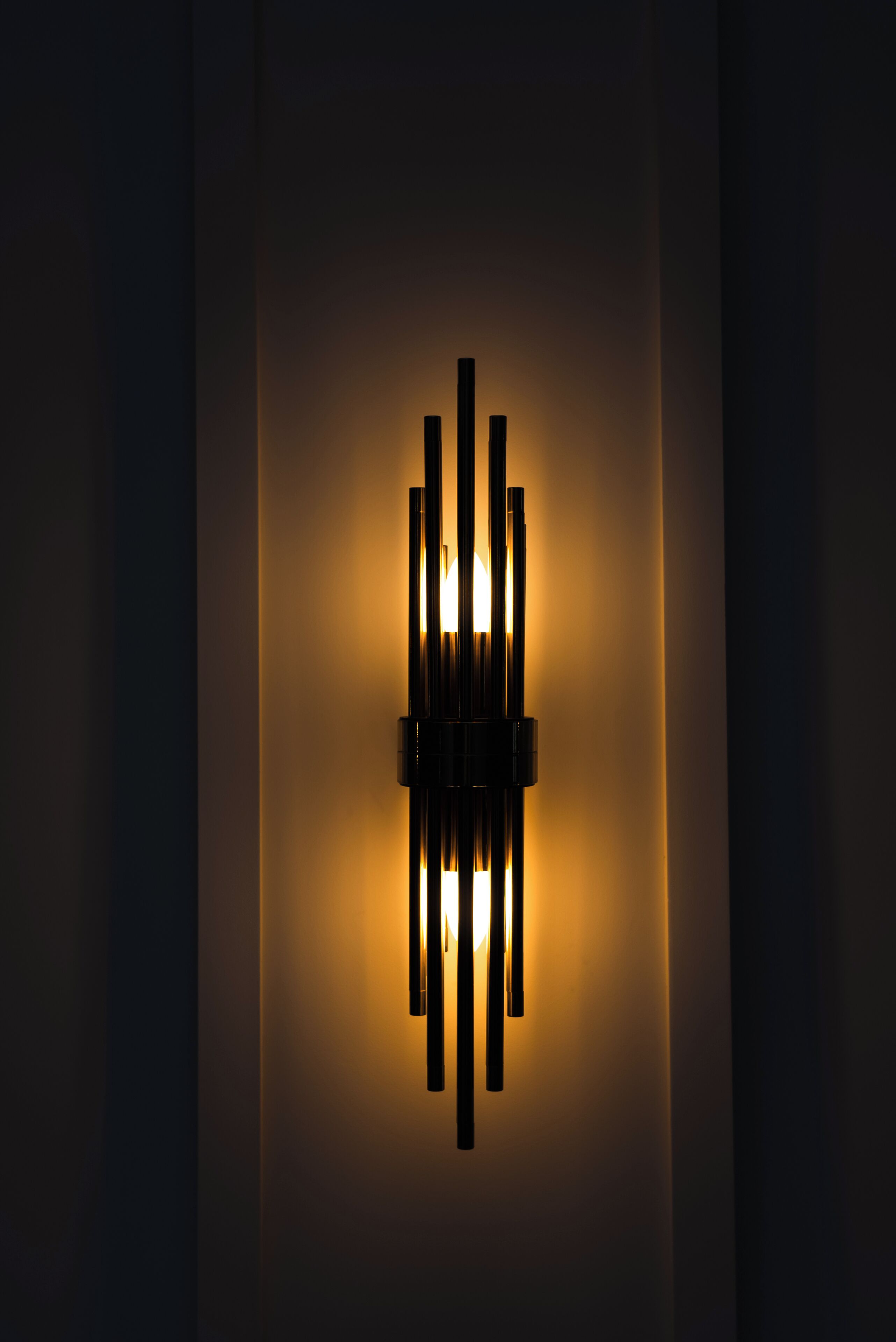 A wall-mounted light fixture with multiple vertical elements.