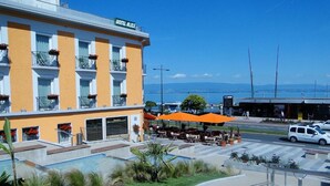 A hotel with a pool, outdoor seating, and a view of the water.