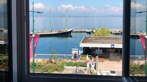 A marina with boats docked, a small building with a sign, and a clear view of the water.