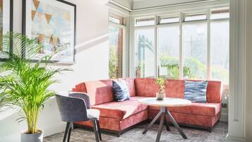 A modern living room with a red sectional sofa, a round coffee table, and a potted plant.