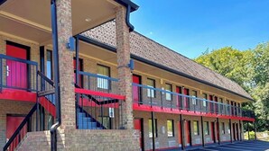 A motel with a brick facade, multiple balconies, and a parking lot with handicapped parking.