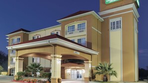 A La Quinta Inn & Suites building with a covered entrance, multiple floors, and a sign indicating the name.