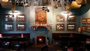 A cozy restaurant with a fireplace, framed pictures on the walls, and a rustic decor. - Brown Trout Golf & Country Inn (Coleraine)