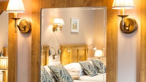 A hotel room with a large mirror, wooden headboard, and bedside lamps. - Brown Trout Golf & Country Inn (Coleraine)