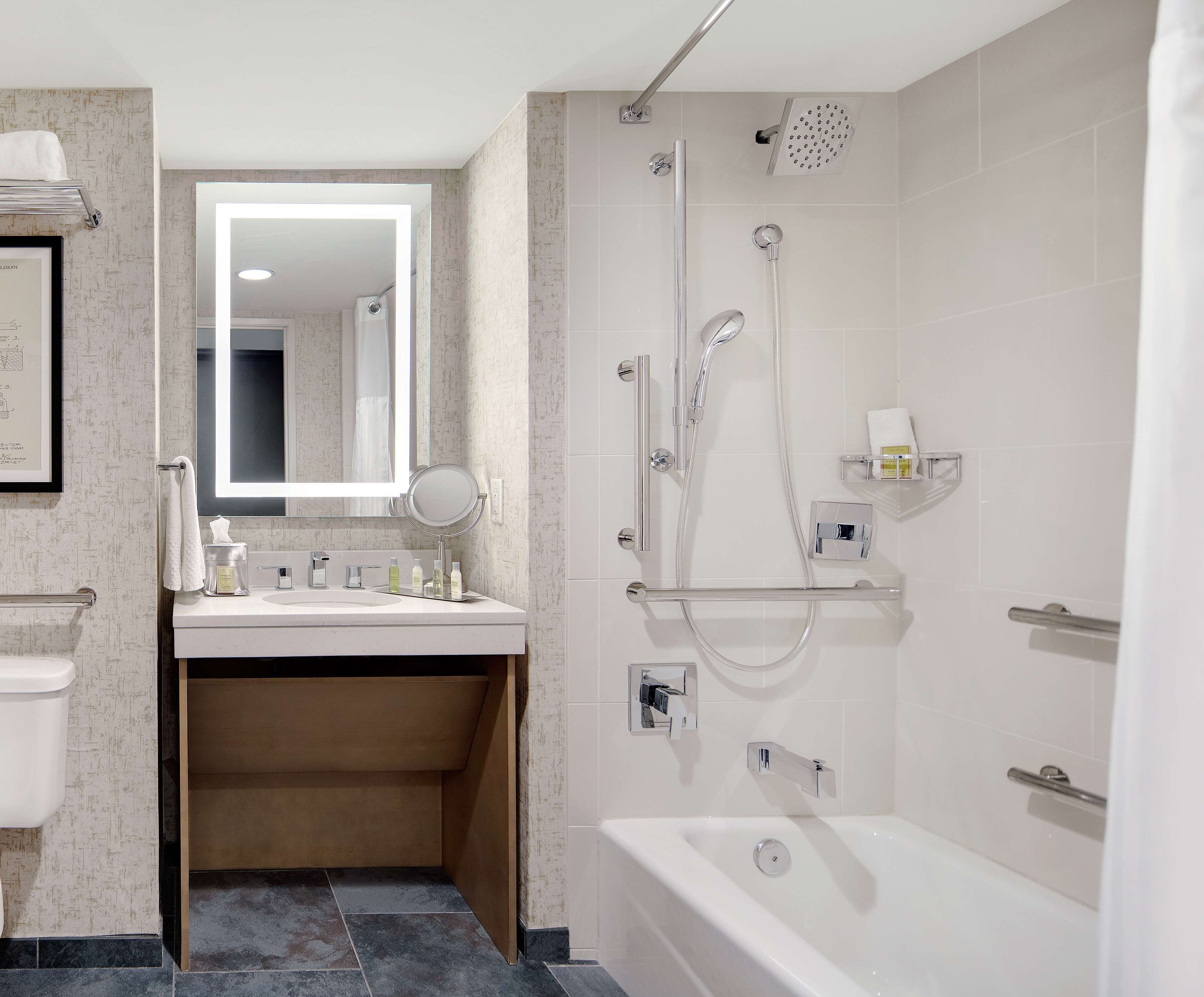 Ein modernes Badezimmer mit Waschbecken, Spiegel und Dusche.