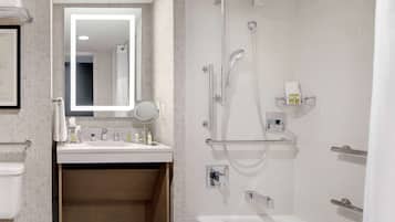 Een moderne badkamer met een wastafel, spiegel en douche.