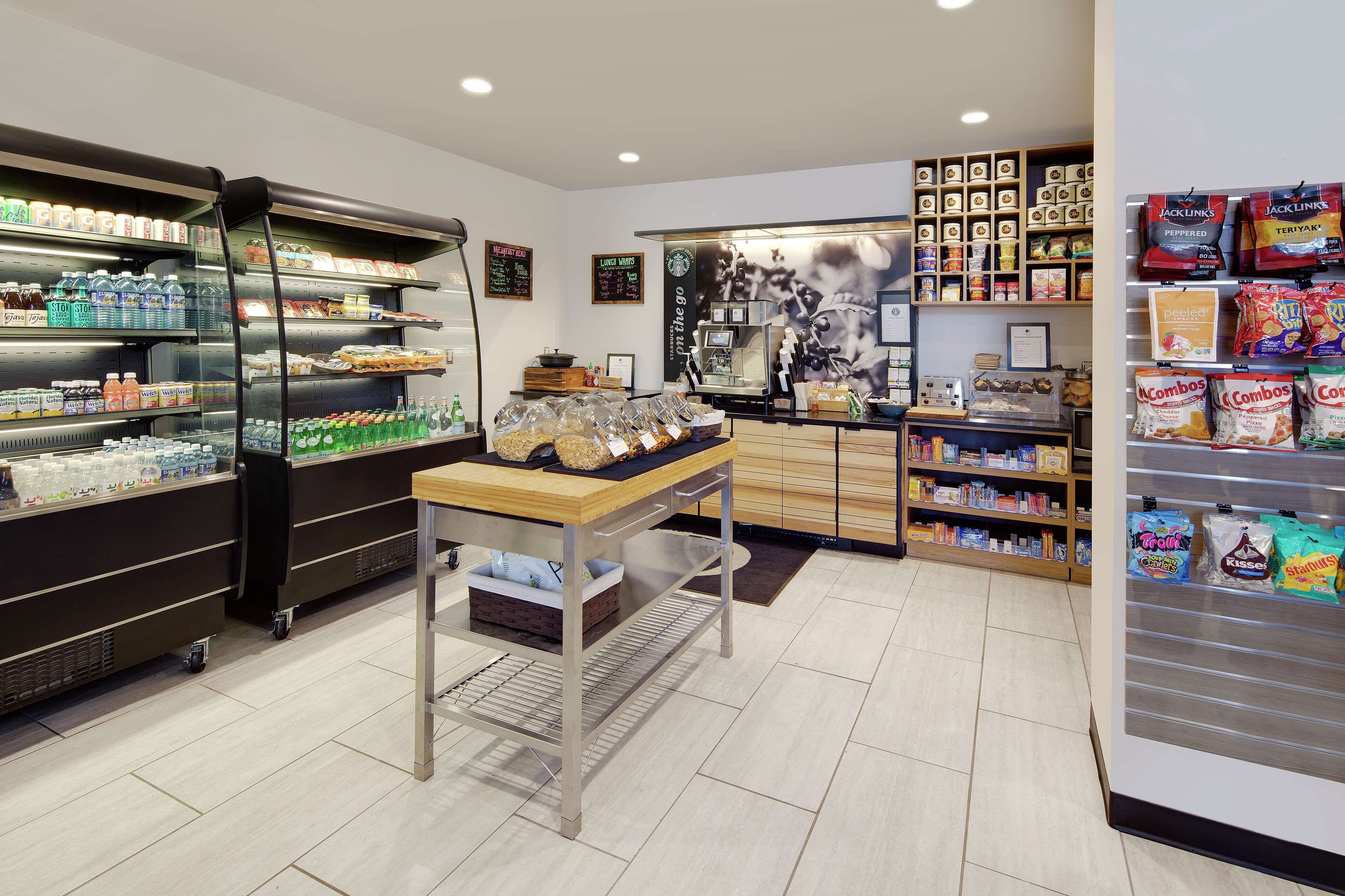 A clean, well-organized store with shelves stocked with snacks, beverages, and other items.