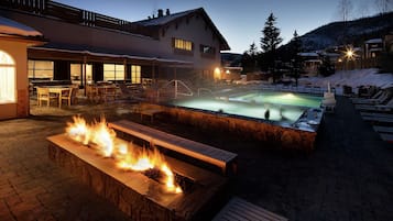 Una piscina al aire libre, sillones reclinables de piscina