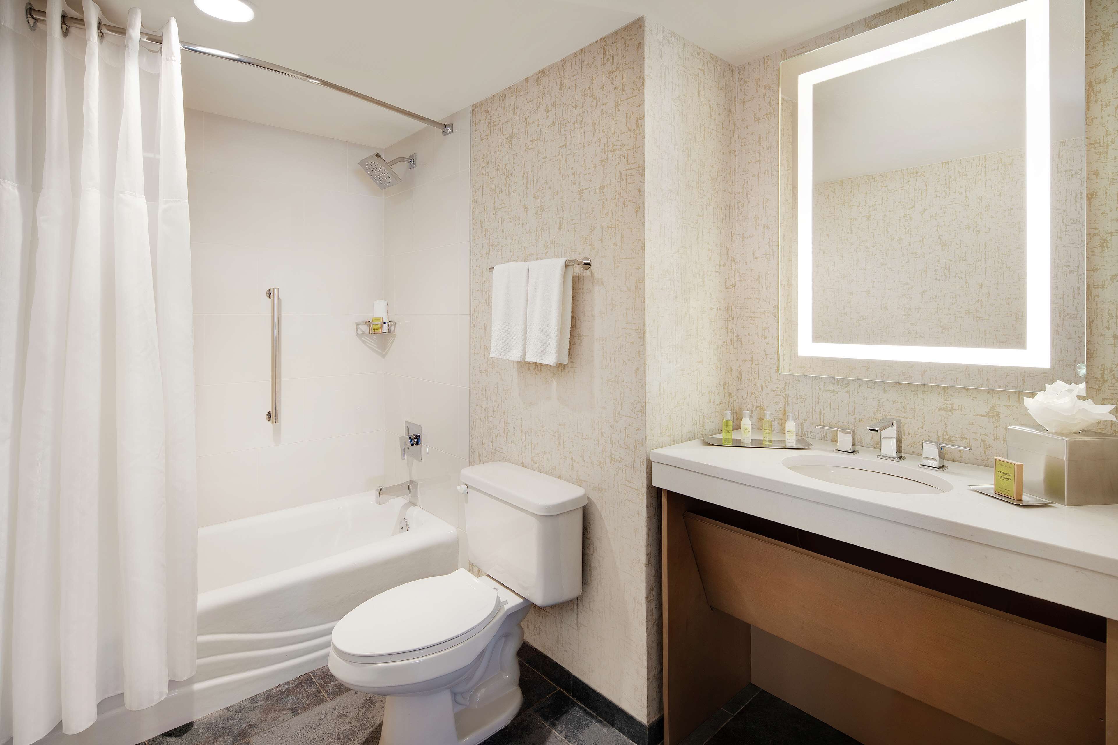 A modern bathroom with a bathtub, toilet, and sink.