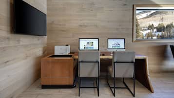 A modern office with two desks, a large monitor, and a computer.