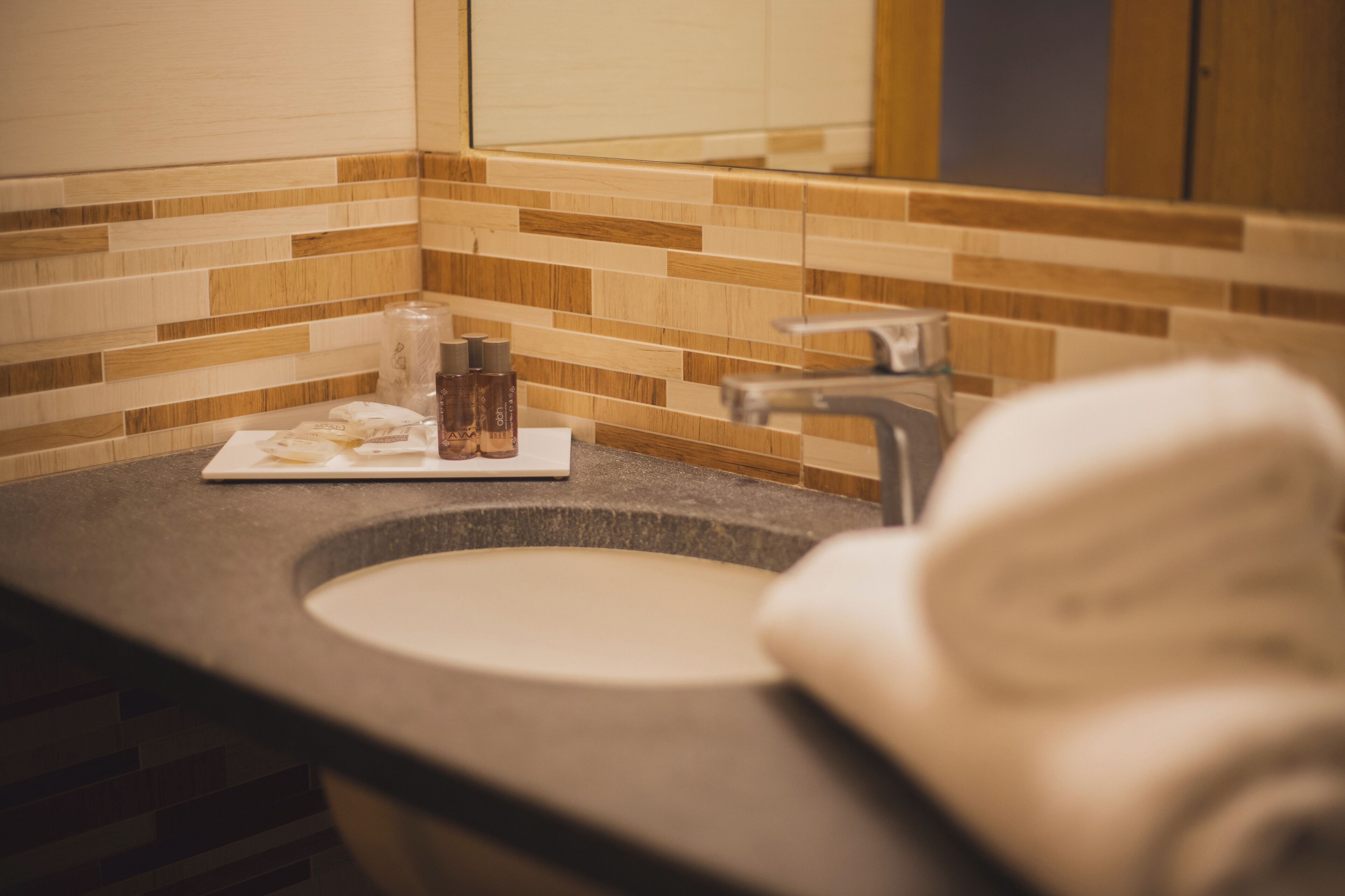 A bathroom with a sink, mirror, and toiletries.