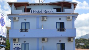 A multi-story hotel named "Hotel Beach" with balconies and air conditioning units. - Beach Hotel (Diamante)