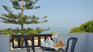 A balcony with a table set for breakfast, overlooking a coastal view. - Beach Hotel (Diamante)