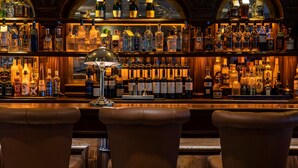 A bar with leather barstools and a variety of liquor bottles. - Headfort Arms Hotel (Kells)