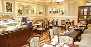 Comedor con bufé, espejos ornamentados y muebles clásicos.