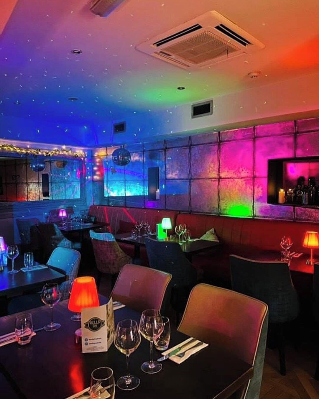 Un interior de restaurante con mesas, sillas y una zona de bar.