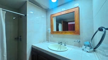 Ein Badezimmer mit Dusche, Waschbecken und Spiegel.