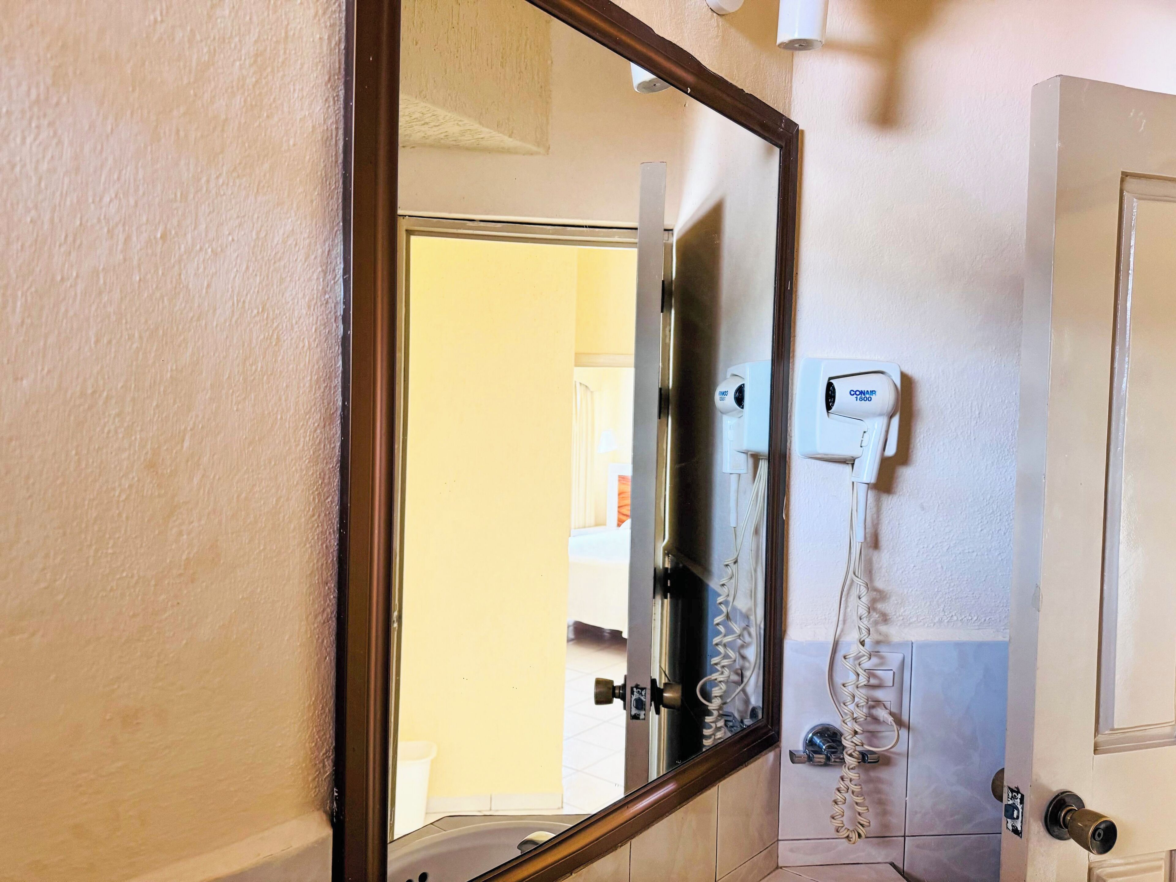 Une salle de bain avec un miroir, une douche et des toilettes.