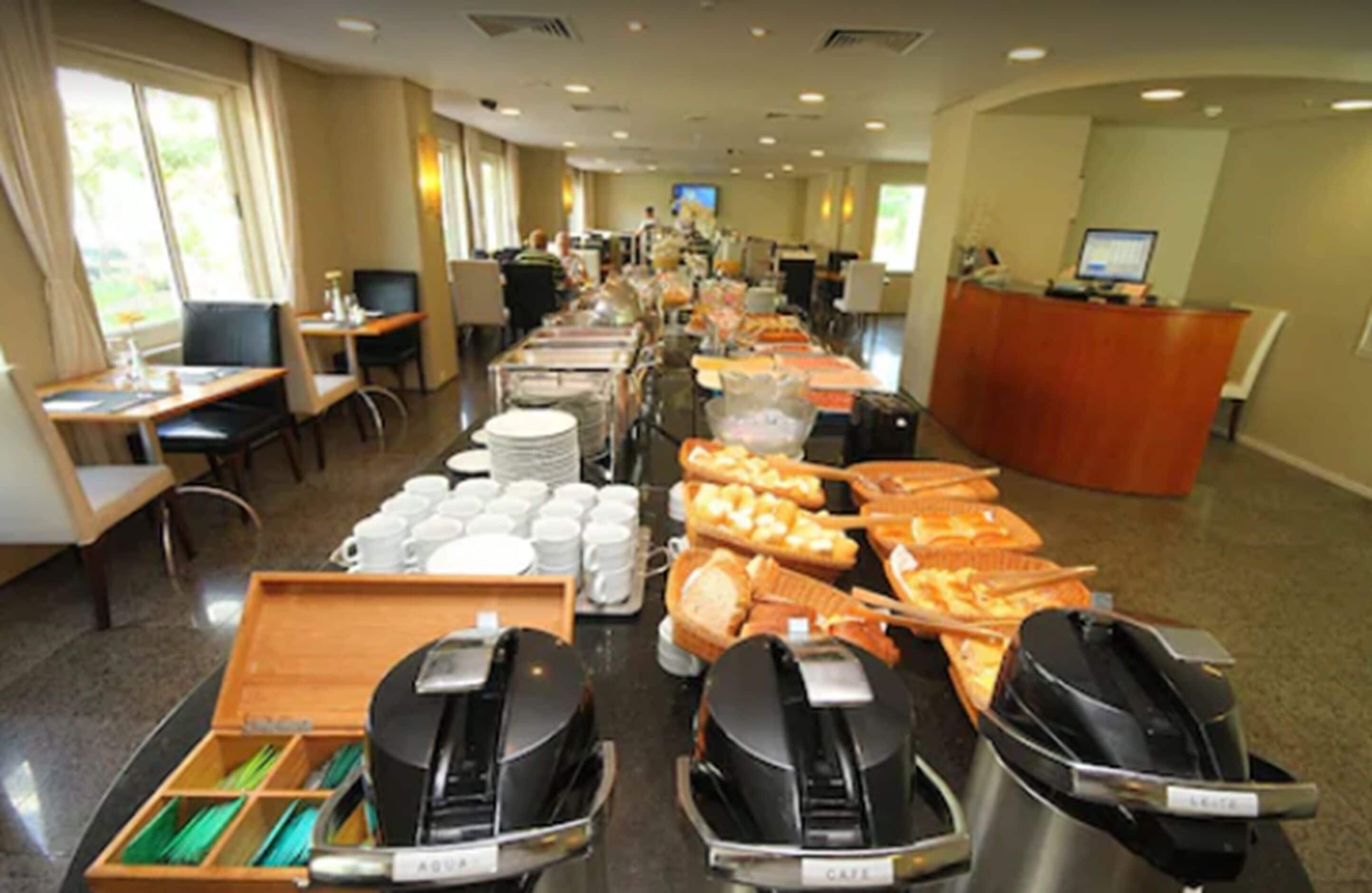 Un espace buffet proposant divers plats, des machines à café et un comptoir d’accueil.