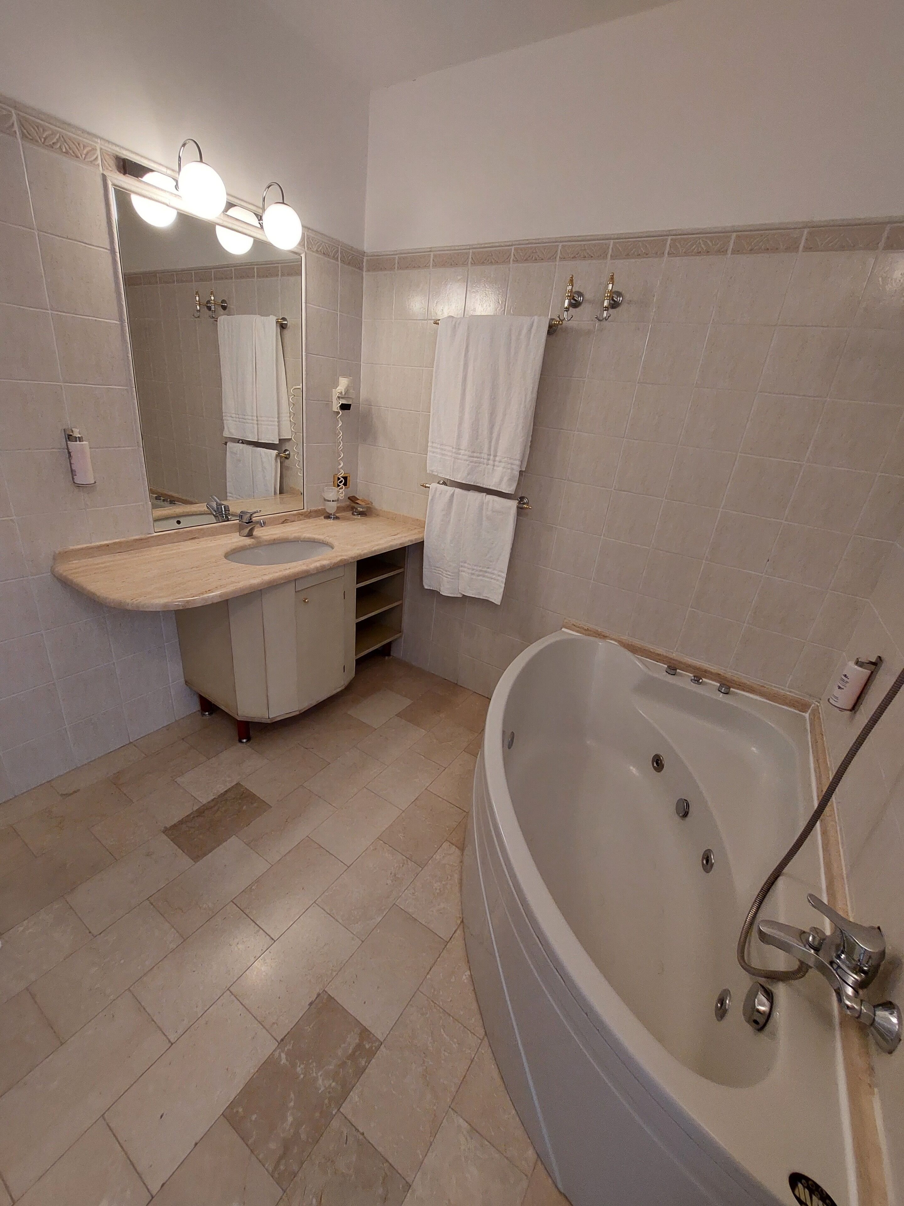 Une salle de bain avec une baignoire, un lavabo, un miroir et un porte-serviettes.