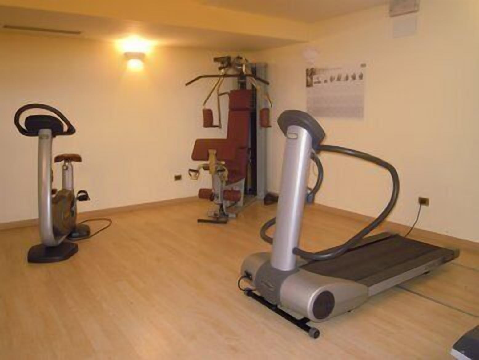Una stanza con tapis roulant, ellittica e cyclette.