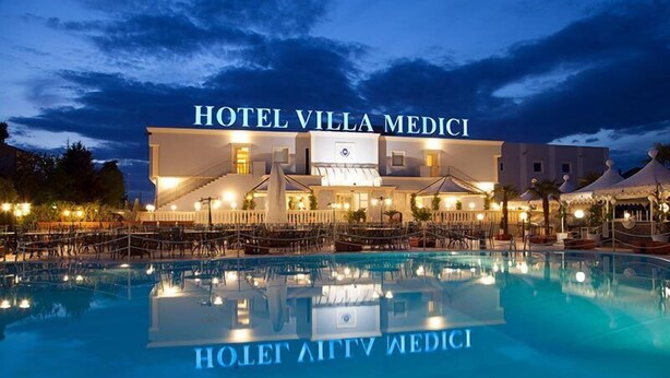 Hotel Villa Medici mit Pool und Sitzbereich im Freien.