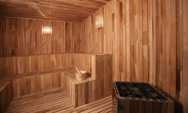 Una sauna de madera con bancos y estufa de leña.