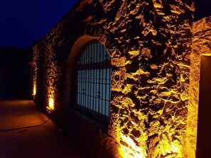 A stone building with a metal gate and warm lighting.