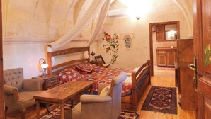 Ein Zimmer mit einem Bett, einem Sessel, einem Tisch und einem Holzschrank.