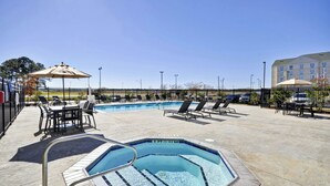An outdoor swimming pool with lounge chairs and a table, surrounded by a fence. - Residence Inn by Marriott Gulfport-Biloxi Airport (Gulfport)