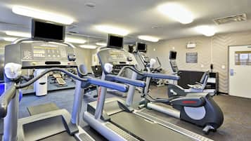 Une salle de sport équipée de tapis de course, d’appareils elliptiques et de vélos d’appartement.