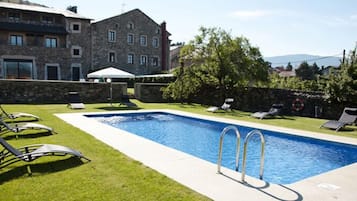 Una piscina al aire libre, tumbonas