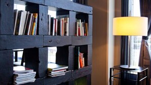 Une bibliothèque avec des livres et une lampe.