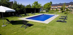 Una piscina al aire libre, tumbonas