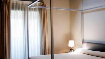 Una cama con dosel en una habitación con techo inclinado y vigas de madera.