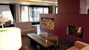 Un salon moderne avec une cheminée, un canapé, une table basse et une lampe.