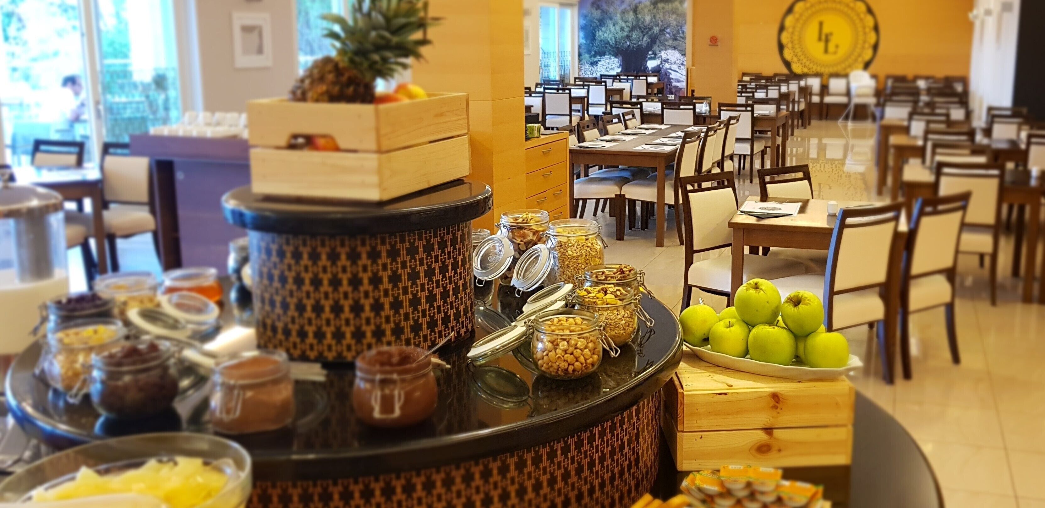 Una barra de buffet con diversos alimentos y una presentación de frutas.