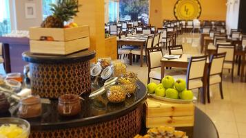 Una barra de buffet con diversos alimentos y una presentación de frutas.